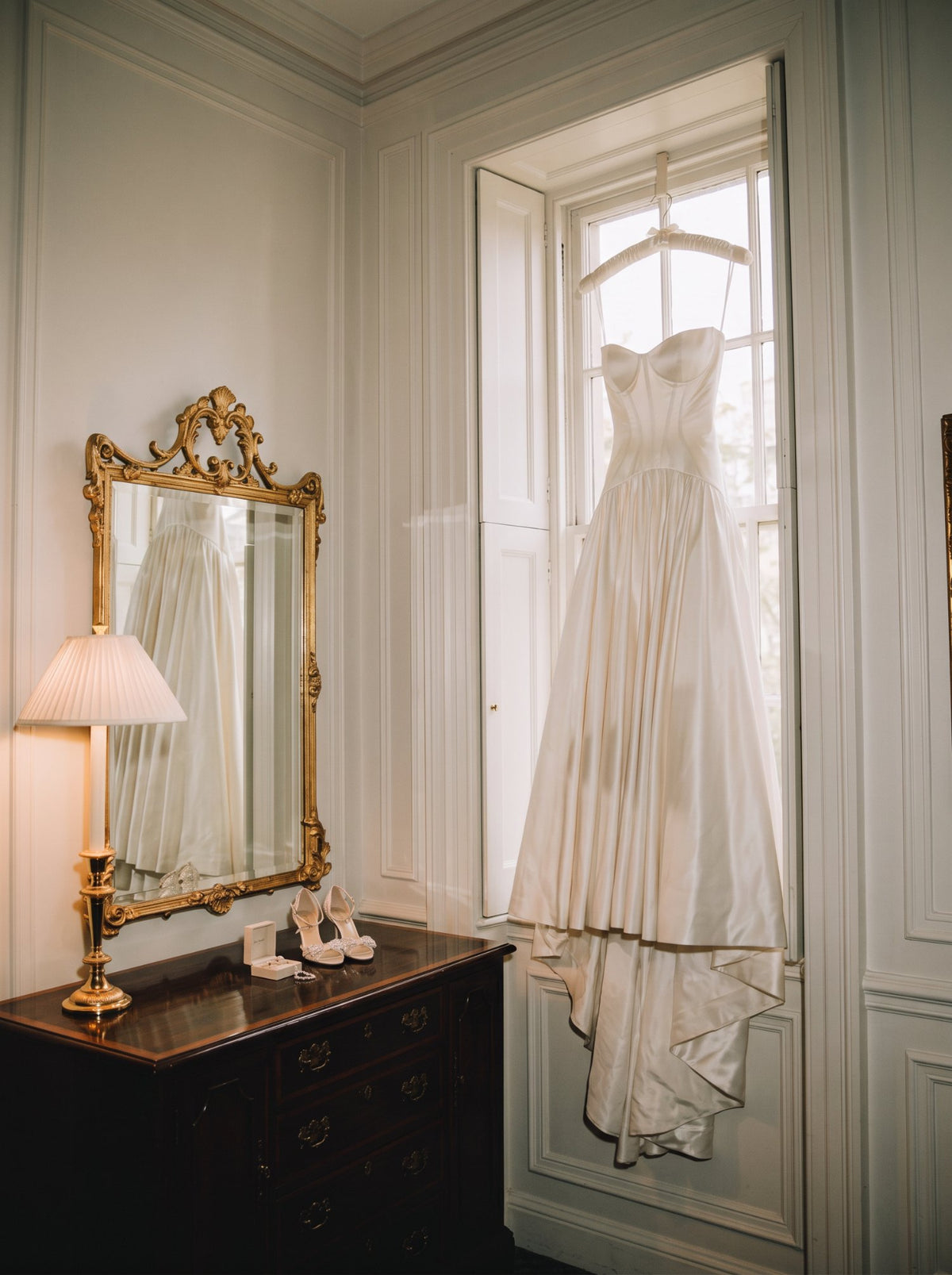 L'abito da sposa appeso alla finestra, nella luce del mattino