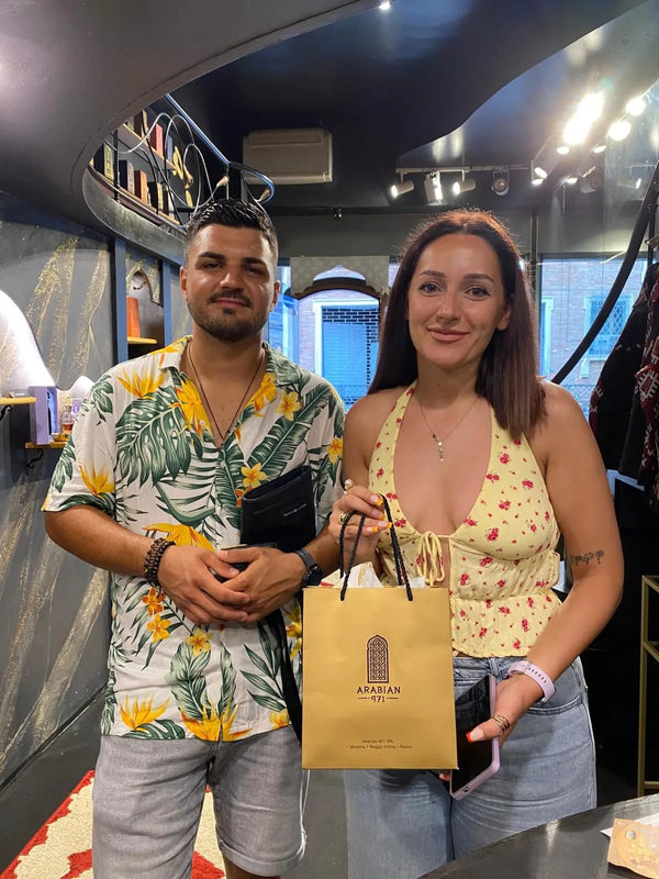 Due clienti in boutique con la busta dorata Arabian 971.