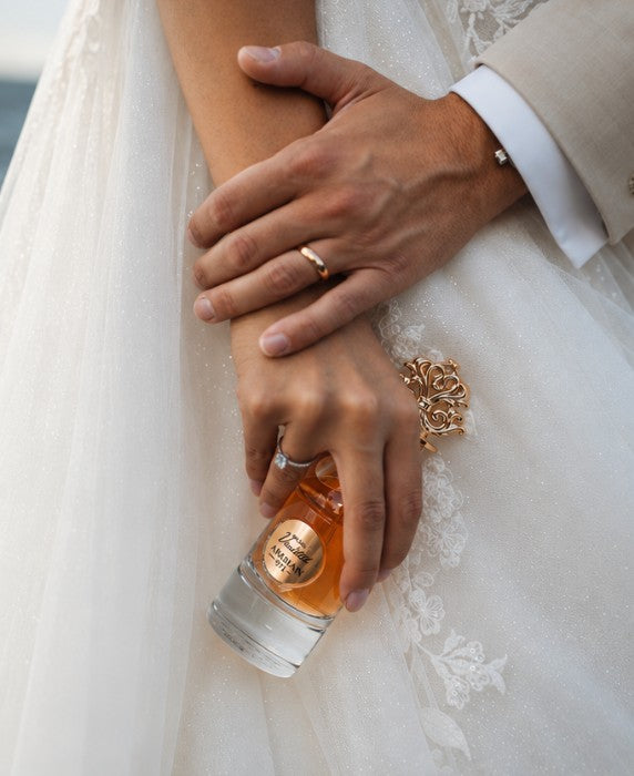 Le mani degli sposi: le fedi e la boccetta di profumo