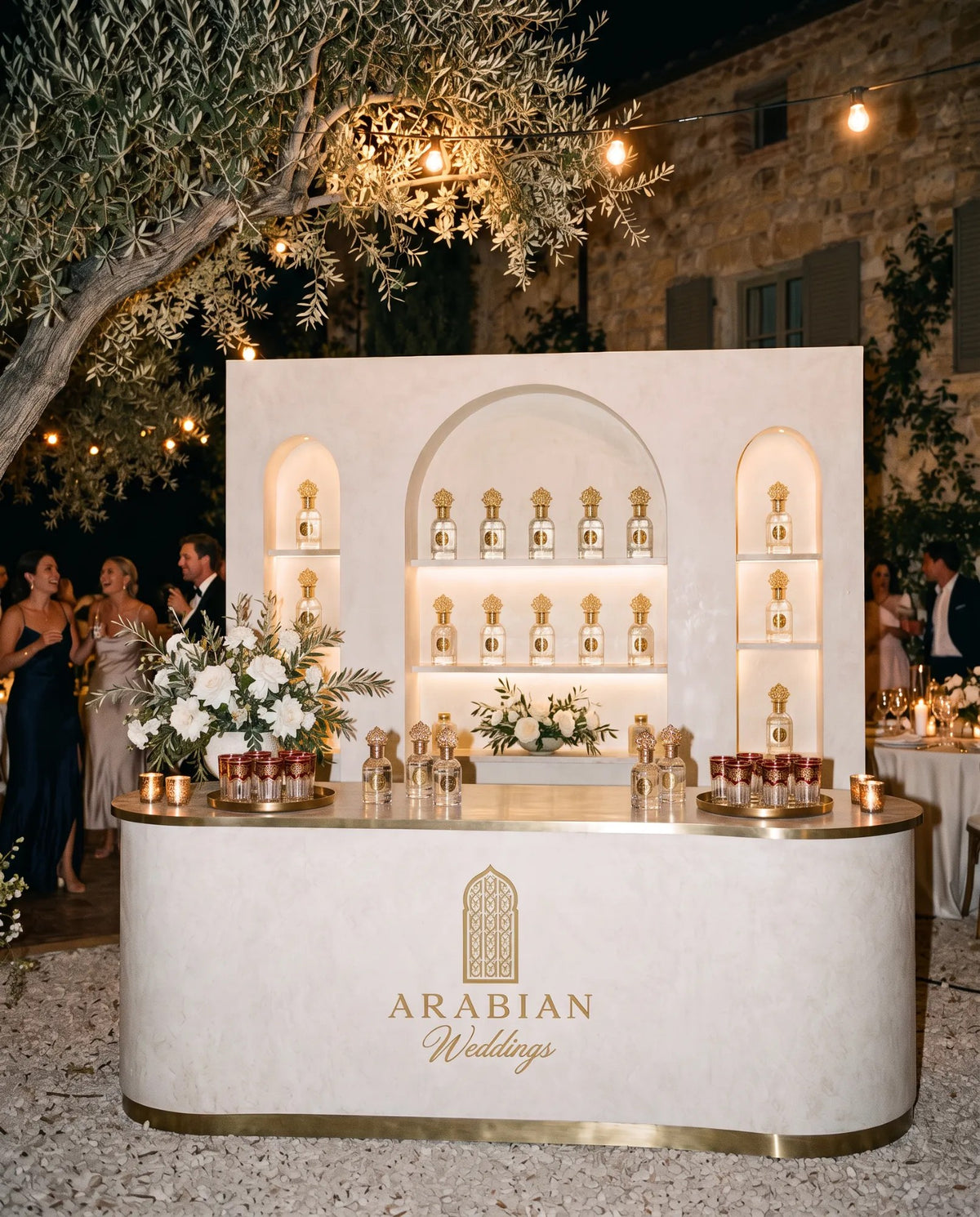Il Parfum Bar Arabian Weddings allestito alla festa, sotto un ulivo con le luci della sera