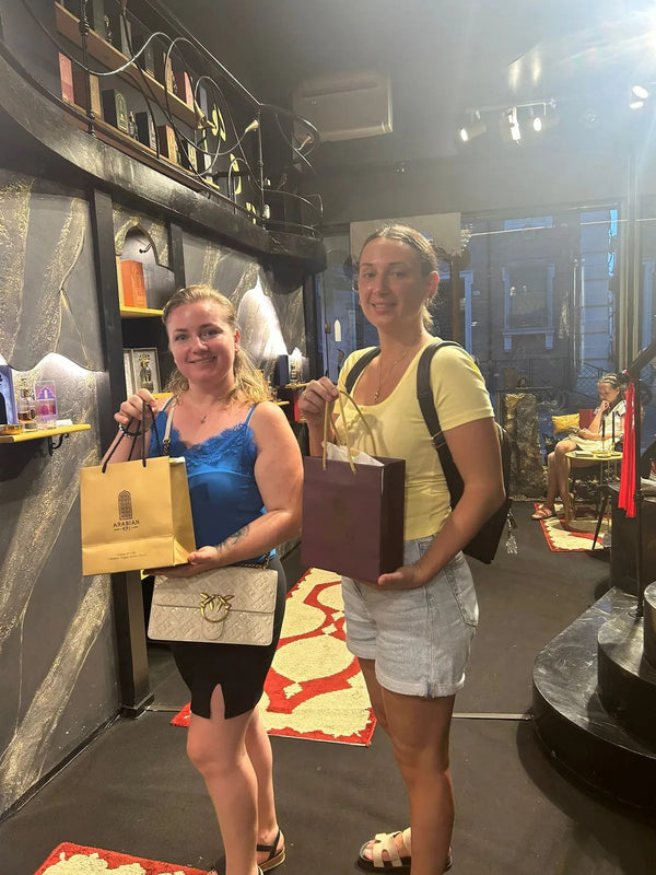 Due clienti in boutique con le buste Arabian 971 appena ritirate.