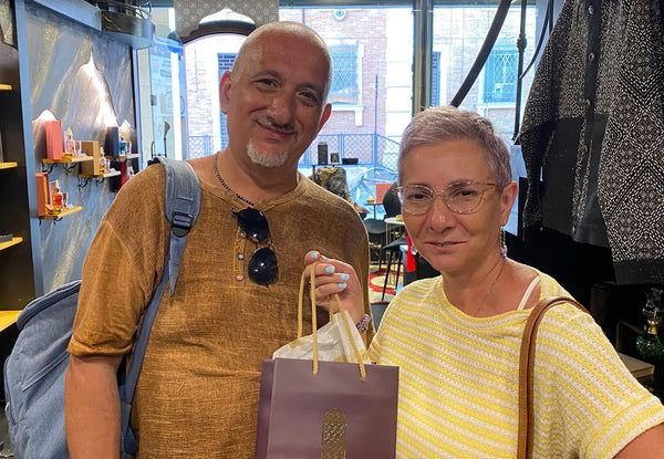 Due clienti in boutique con la busta Arabian 971 dei loro acquisti.
