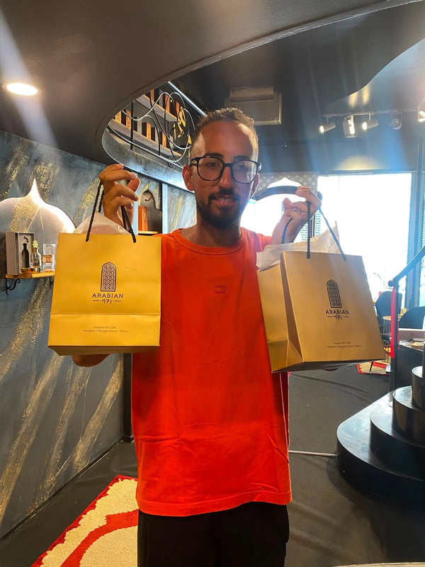 Un cliente in boutique con due buste dorate Arabian 971.