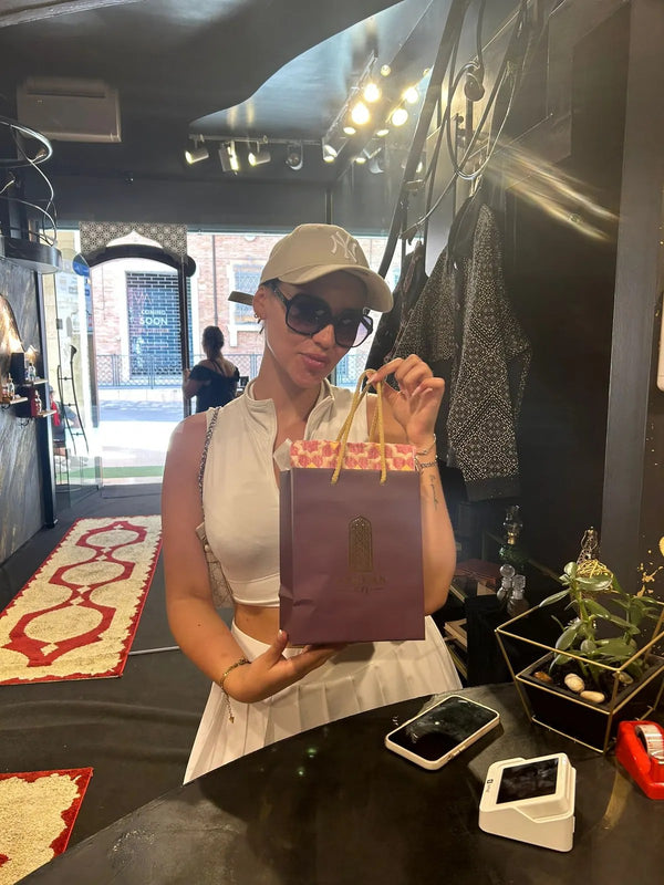 Una cliente in boutique con la busta rosa Arabian 971 appena ritirata.