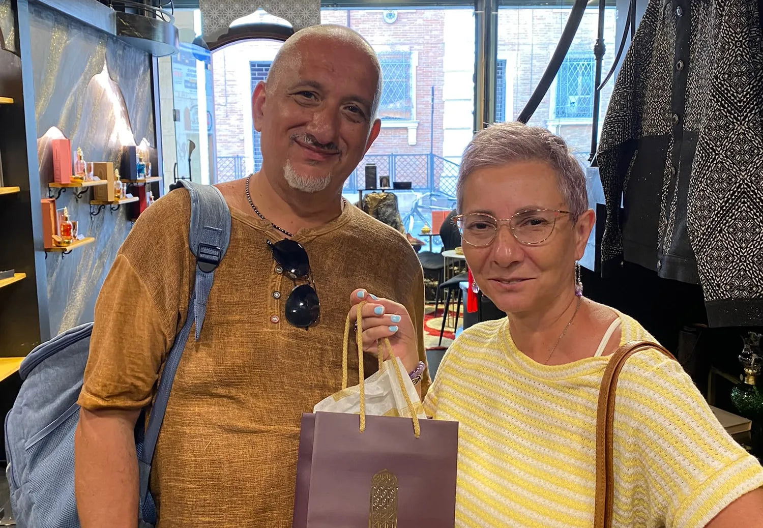 Due clienti in boutique con la busta Arabian 971 dei loro acquisti.